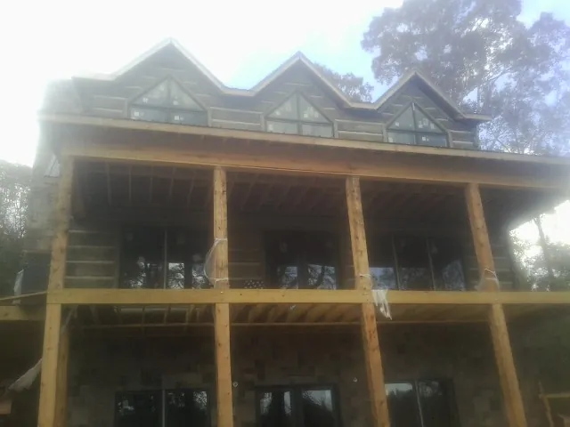 Dormers and porch framing on a large log home under construction — Roof Coating work by our crew in New Pine Creek