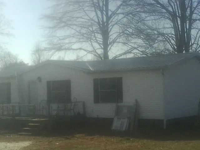 New metal roof on a white painted brick home on a foggy morning in New Pine Creek