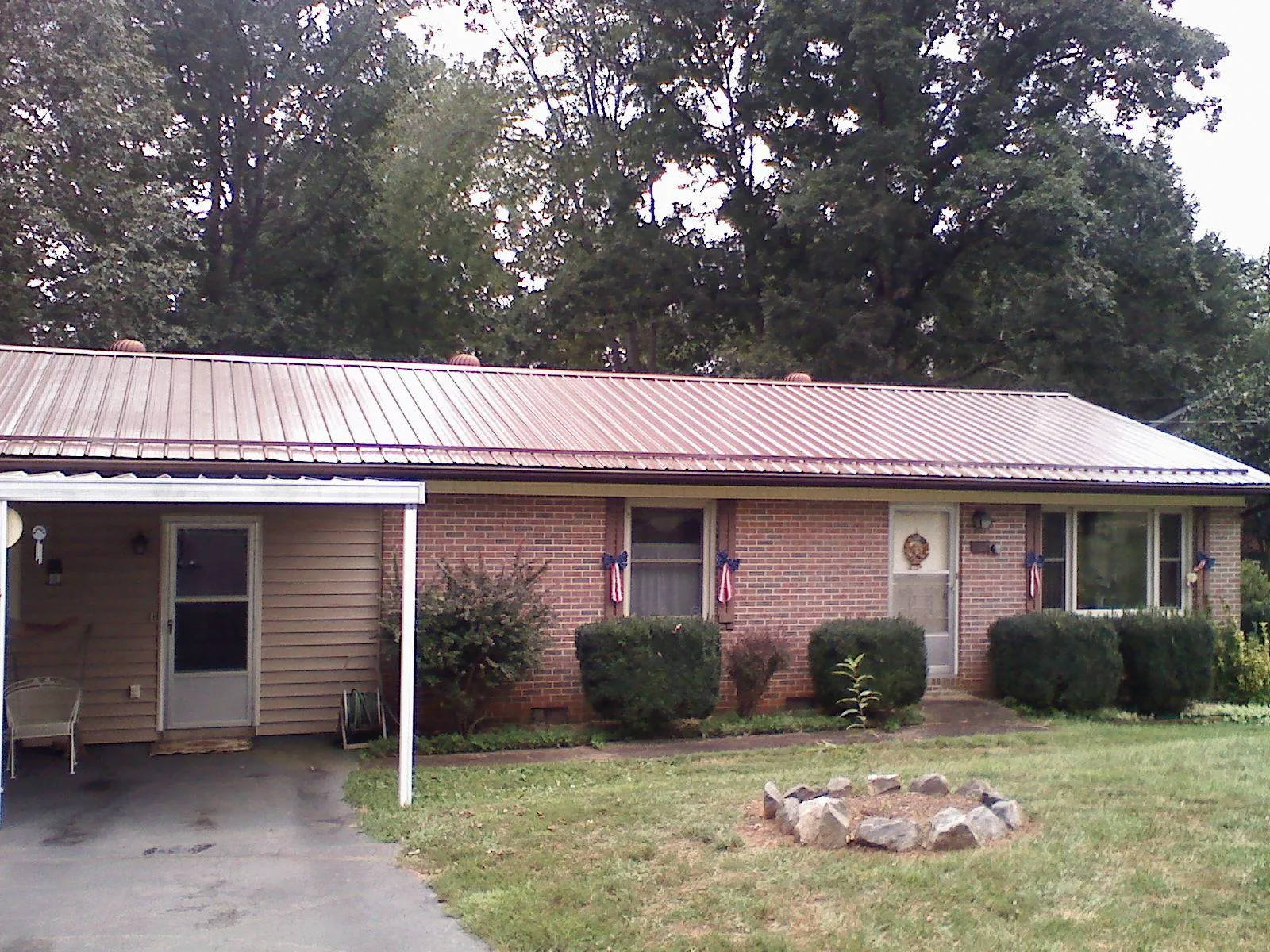Bronze metal roof and carport on a brick ranch home — Roof Repair work by our crew in New Pine Creek